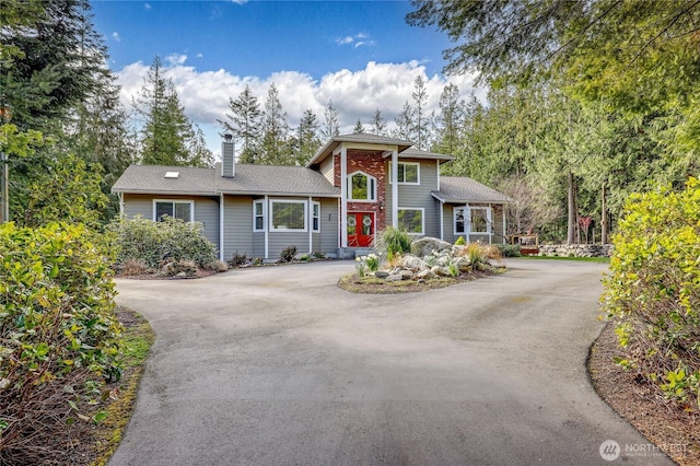 view of front of home with aphalt driveway and a chimney