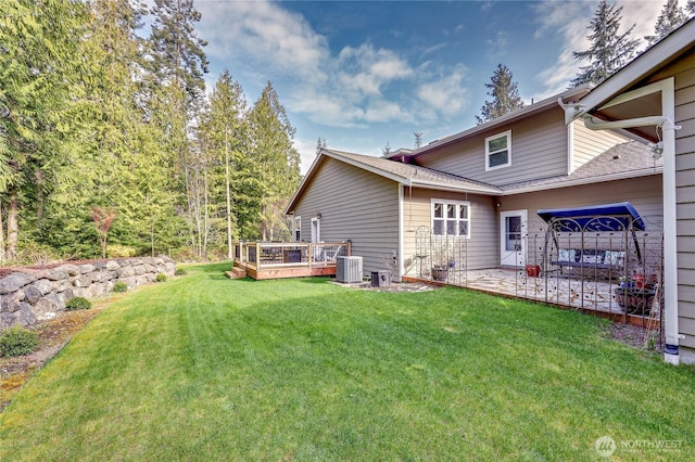 back of property with a patio, a deck, roof with shingles, a lawn, and cooling unit