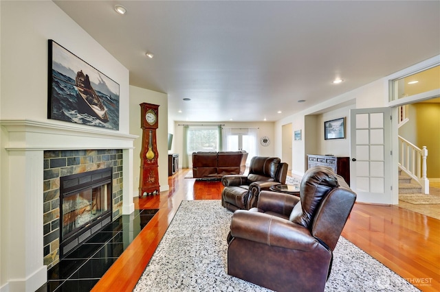 living room featuring a fireplace, recessed lighting, wood finished floors, and stairway