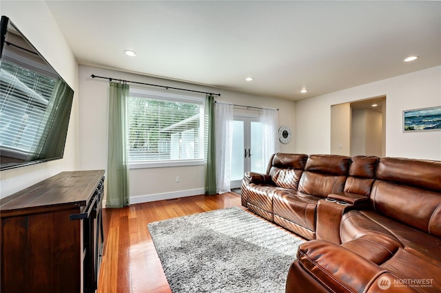 living area featuring baseboards, recessed lighting, french doors, and light wood-style floors