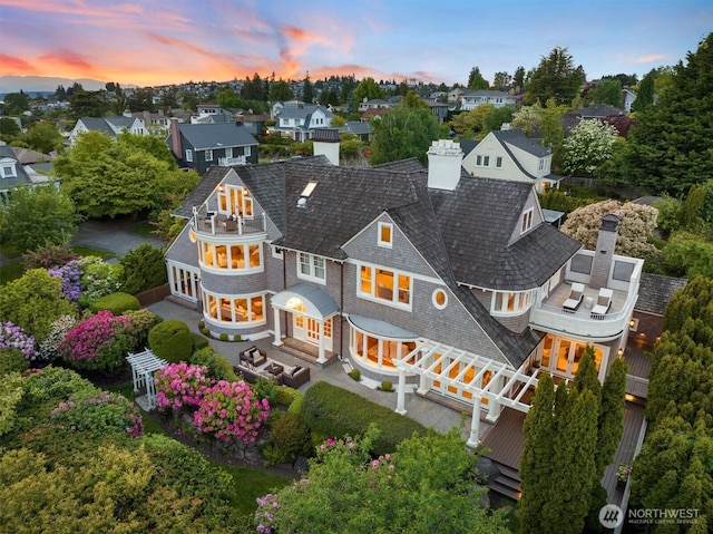 2720 W Galer St, Seattle, WA 98199 - back of house at dusk with a balcony, a chimney, a patio, french doors, and a residential view