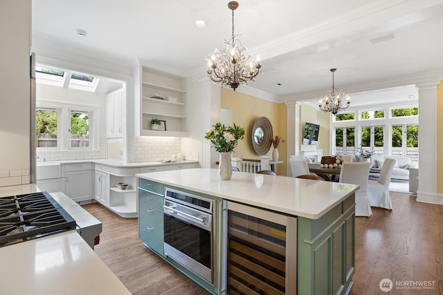 2720 W Galer St, Seattle, WA 98199 - kitchen with wine cooler, open shelves, a chandelier, wood finished floors, and light countertops