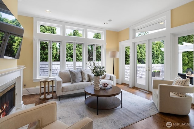 2720 W Galer St, Seattle, WA 98199 - living area with french doors, a baseboard heating unit, a tiled fireplace, wood finished floors, and recessed lighting