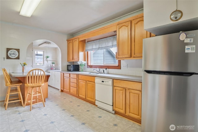 77 S Welcome Slough, Cathlamet, WA 98612 - kitchen with a sink, freestanding refrigerator, a kitchen bar, dishwasher, and arched walkways