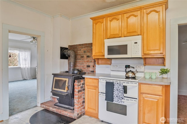 77 S Welcome Slough, Cathlamet, WA 98612 - kitchen with crown molding, white appliances, ceiling fan, light carpet, and a wood stove