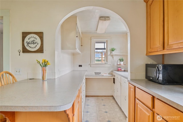 77 S Welcome Slough, Cathlamet, WA 98612 - kitchen with black microwave, light countertops, arched walkways, and a peninsula