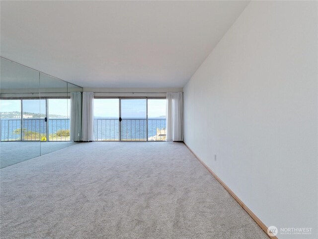 1156 Alki Ave SW Unit 204, Seattle, WA 98116 - carpeted spare room with a water view and baseboards
