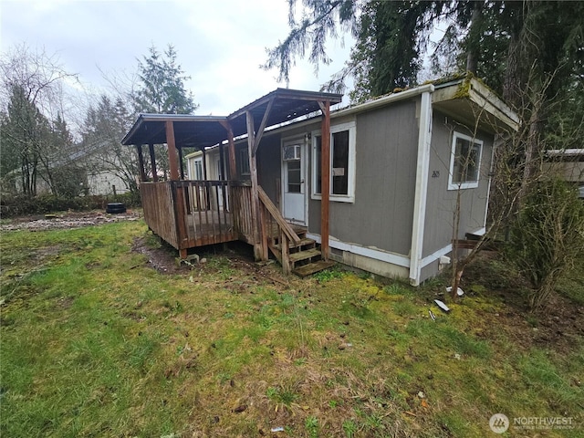 back of house with a lawn and a deck