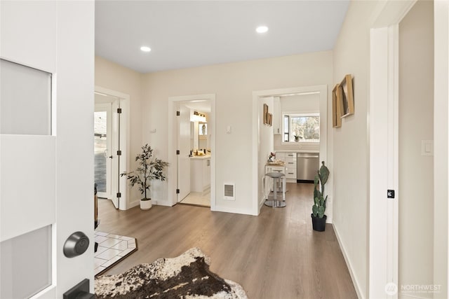 foyer entrance featuring wood finished floors, recessed lighting, baseboards, and visible vents