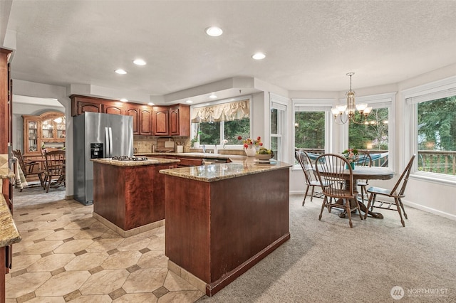 11312 134th Avenue Ct E, Puyallup, WA 98374 - kitchen featuring tasteful backsplash, a textured ceiling, light stone countertops, a kitchen island, and stainless steel appliances