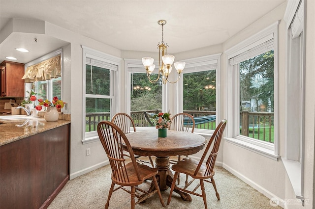 11312 134th Avenue Ct E, Puyallup, WA 98374 - dining room featuring light colored carpet, baseboards, and a chandelier