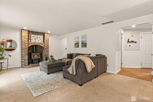 11312 134th Avenue Ct E, Puyallup, WA 98374 - carpeted living area featuring visible vents, a wood stove, recessed lighting, and wainscoting