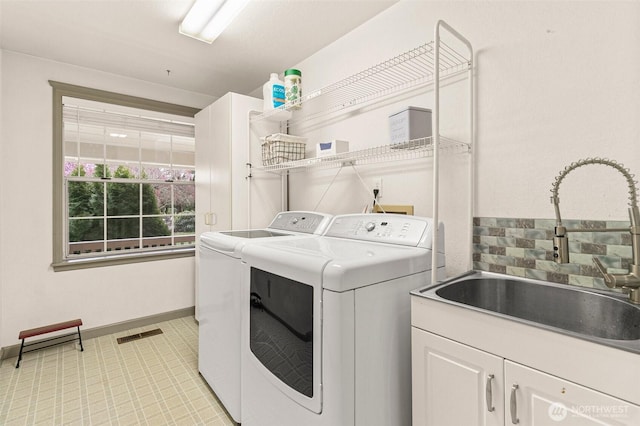 11312 134th Avenue Ct E, Puyallup, WA 98374 - washroom featuring baseboards, washing machine and dryer, visible vents, cabinet space, and a sink