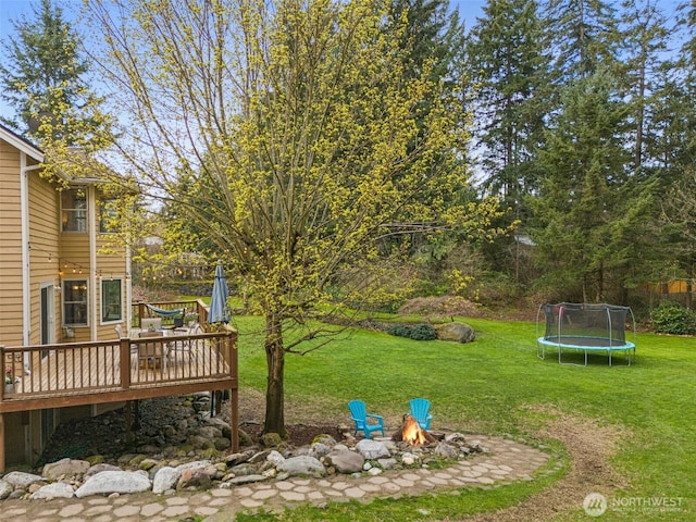 11312 134th Avenue Ct E, Puyallup, WA 98374 - view of yard featuring a trampoline, a wooden deck, and an outdoor fire pit