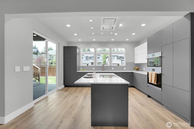 19504 141st Street Ct E, Bonney Lake, WA 98391 - kitchen with modern cabinets, a kitchen island, light wood-style floors, light countertops, and recessed lighting