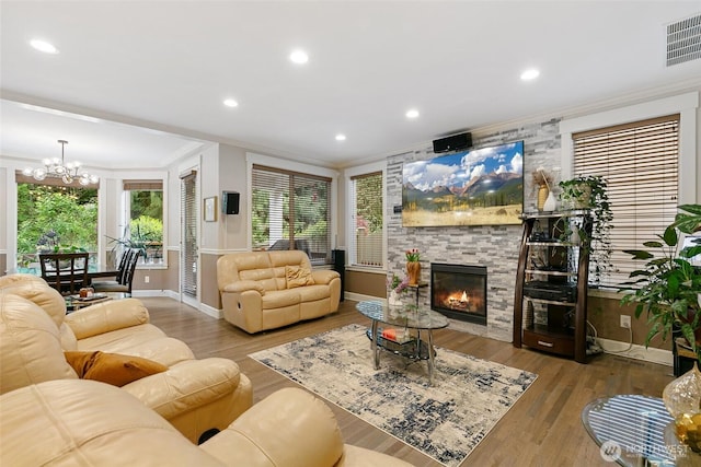 living area featuring crown molding, baseboards, an inviting chandelier, and visible vents