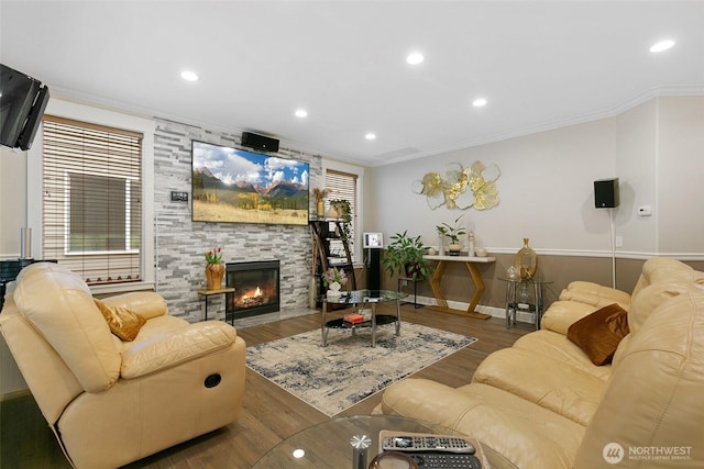 living area featuring ornamental molding, a fireplace, recessed lighting, and wood finished floors