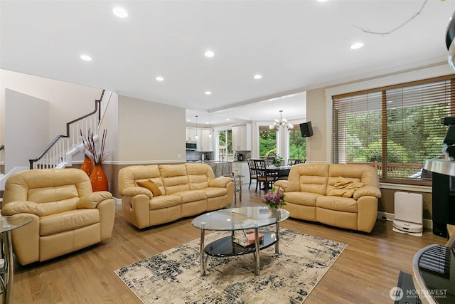living room with stairway, recessed lighting, light wood-type flooring, and a chandelier