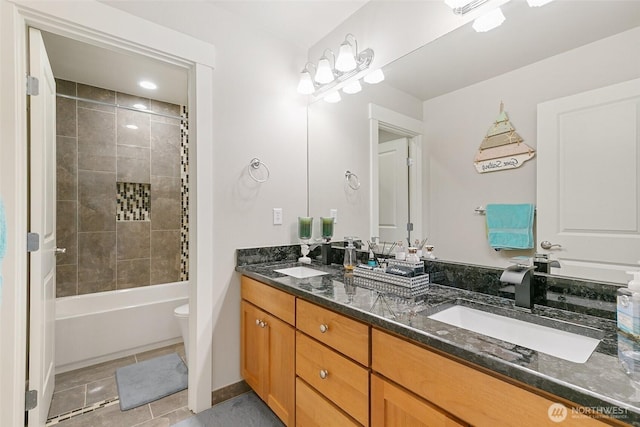 bathroom featuring double vanity, toilet, a sink, and tile patterned flooring