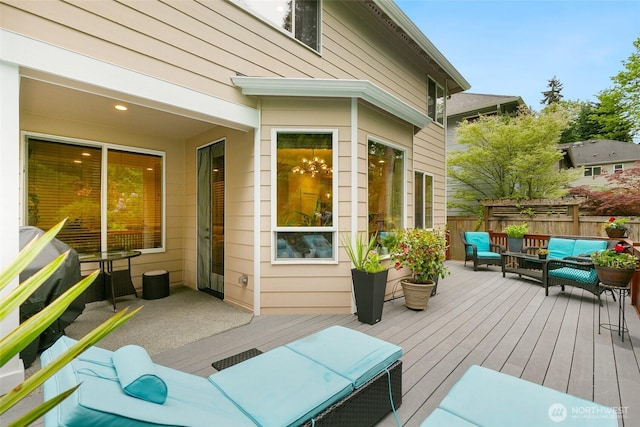 wooden terrace with fence and an outdoor living space
