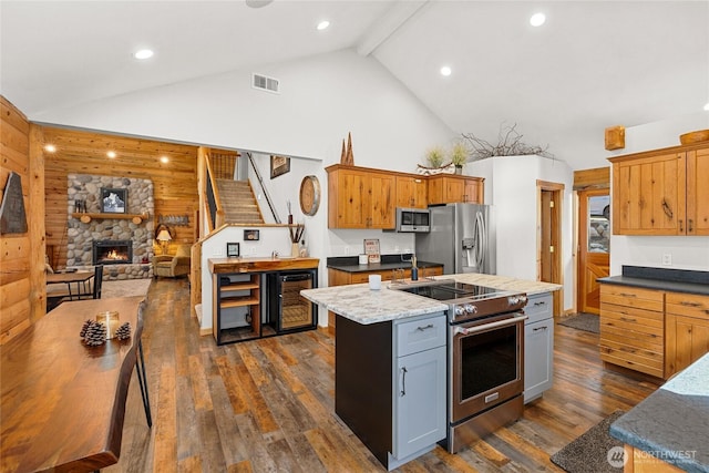 1020 Highland Loop, Ronald, WA 98940 - kitchen with visible vents, a center island, appliances with stainless steel finishes, a fireplace, and dark wood-style floors