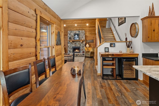 1020 Highland Loop, Ronald, WA 98940 - dining room featuring a stone fireplace, stairway, lofted ceiling, wine cooler, and dark wood-style floors