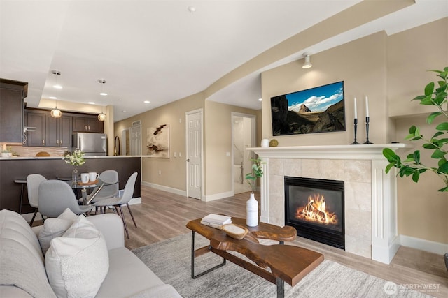 10047 Main St Unit 305, Bellevue, WA 98004 - living area featuring light wood-style flooring, baseboards, recessed lighting, and a tile fireplace
