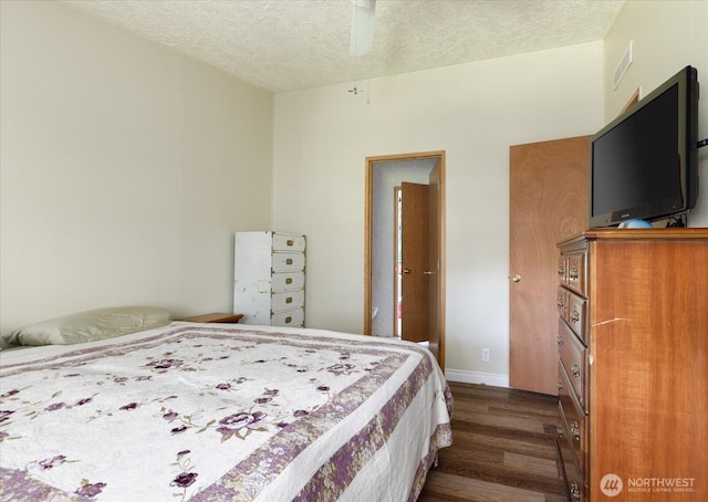 bedroom with dark wood-style flooring, a textured ceiling, a ceiling fan, baseboards, and visible vents