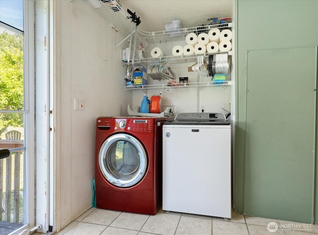 washroom with light tile patterned flooring, laundry area, and washer and clothes dryer
