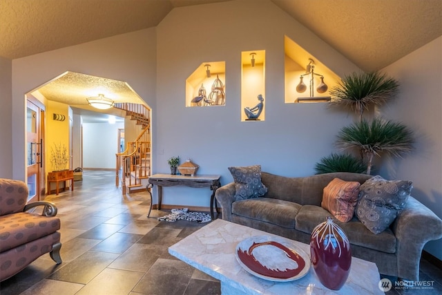 living room with a textured ceiling, stairs, and lofted ceiling