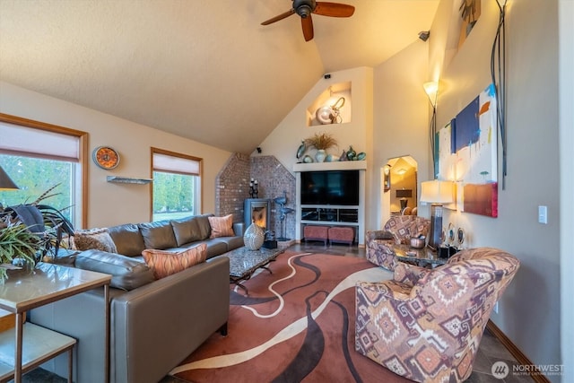 living room featuring baseboards, high vaulted ceiling, and ceiling fan