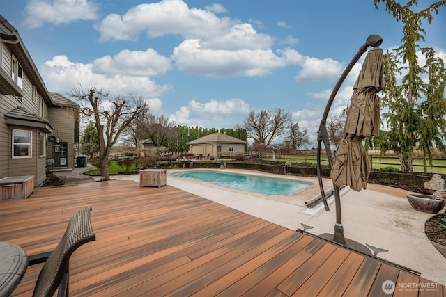 view of pool with a fenced in pool, a wooden deck, and a patio area