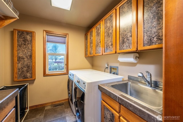 laundry area with independent washer and dryer, cabinet space, a sink, and baseboards