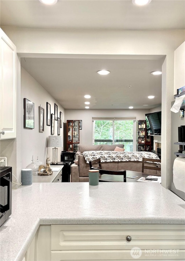23321 Cedar Way Unit J204, Mountlake Terrace, WA 98043 - kitchen featuring open floor plan, white cabinets, recessed lighting, and light stone counters