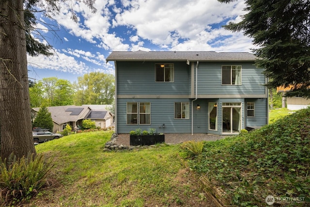 rear view of property featuring a yard