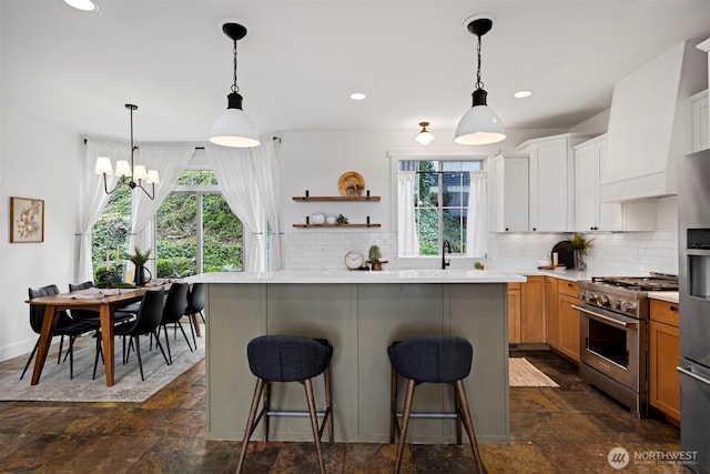 kitchen featuring stainless steel appliances, stone tile flooring, a kitchen breakfast bar, backsplash, and light countertops