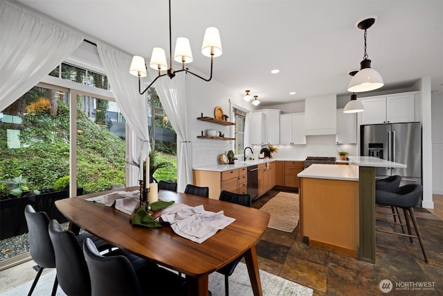 dining area featuring stone finish flooring, a chandelier, and recessed lighting