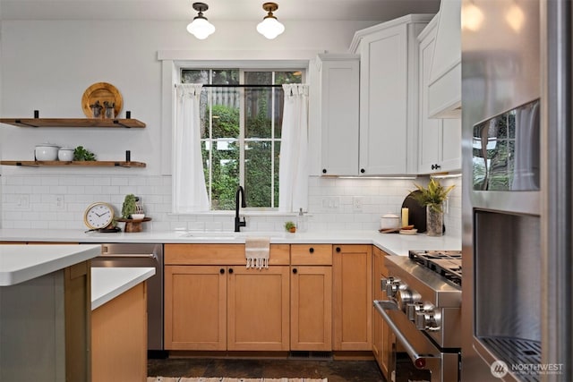 kitchen with a sink, open shelves, stainless steel appliances, light countertops, and tasteful backsplash