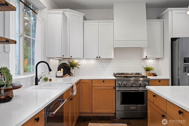 kitchen featuring a sink, decorative backsplash, light countertops, white cabinets, and appliances with stainless steel finishes