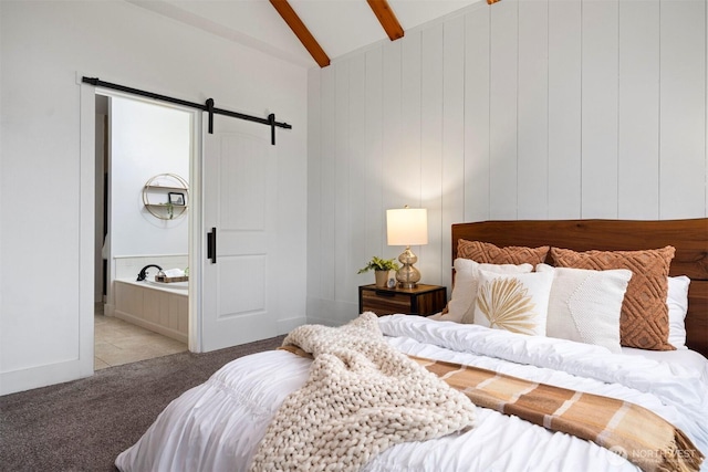 bedroom with lofted ceiling with beams, connected bathroom, a barn door, and light colored carpet