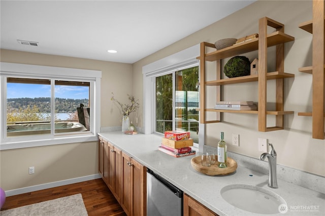 11230 SE 76th Pl, Newcastle, WA 98056 - kitchen featuring visible vents, baseboards, brown cabinets, dark wood-type flooring, and a sink