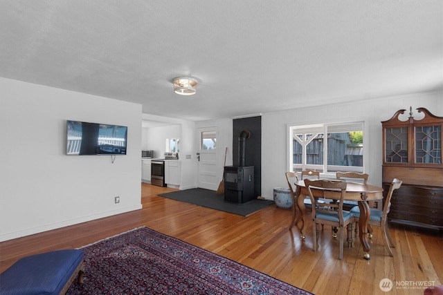 275 State Route 409, Cathlamet, WA 98612 - dining area with a wealth of natural light, baseboards, light wood finished floors, and a wood stove