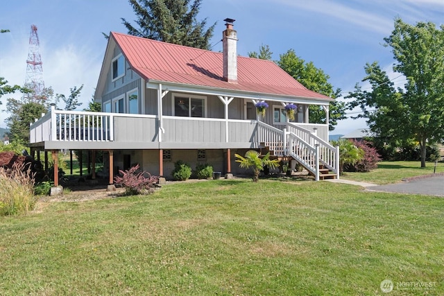 275 State Route 409, Cathlamet, WA 98612 - view of front facade featuring stairs, metal roof, board and batten siding, a front yard, and a chimney