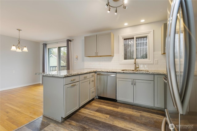 13729 8th Ave S, Burien, WA 98168 - kitchen with a peninsula, a sink, decorative backsplash, gray cabinetry, and appliances with stainless steel finishes