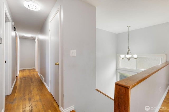13729 8th Ave S, Burien, WA 98168 - hall with light wood finished floors, baseboards, visible vents, a chandelier, and an upstairs landing
