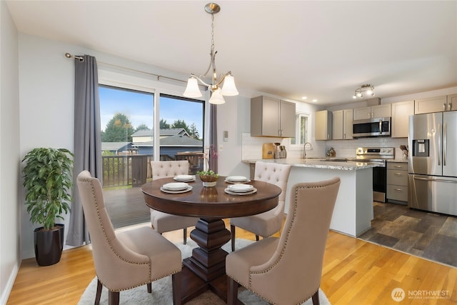 13729 8th Ave S, Burien, WA 98168 - dining space featuring a notable chandelier, wood finished floors, and a healthy amount of sunlight