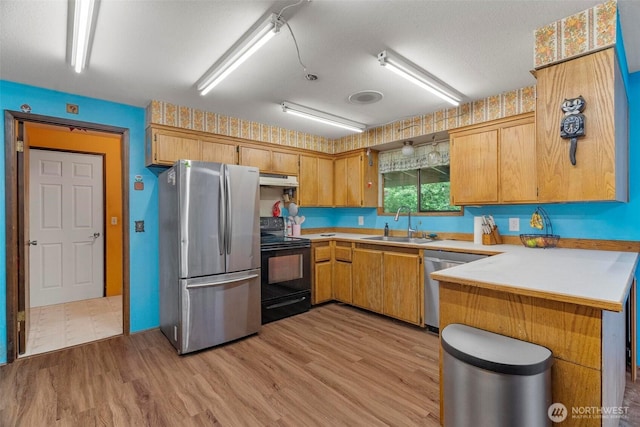 4901 Delta Ln SE, Tumwater, WA 98501 - kitchen featuring appliances with stainless steel finishes, a sink, under cabinet range hood, a peninsula, and light countertops