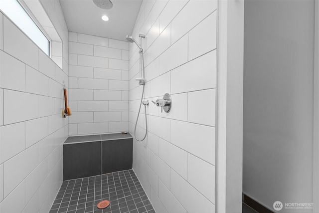 bathroom featuring recessed lighting, tile patterned floors, tile walls, and tiled shower