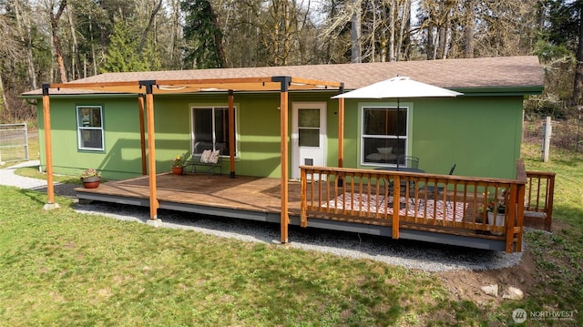 rear view of property with a wooden deck and a yard