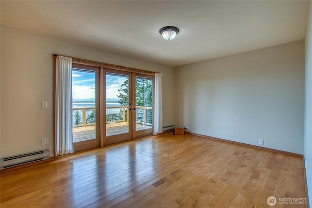 unfurnished room with baseboard heating, a baseboard radiator, and wood finished floors